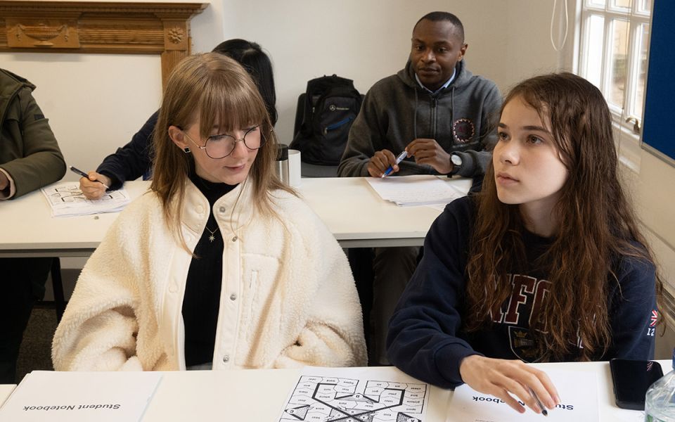 Two girls look at work in school